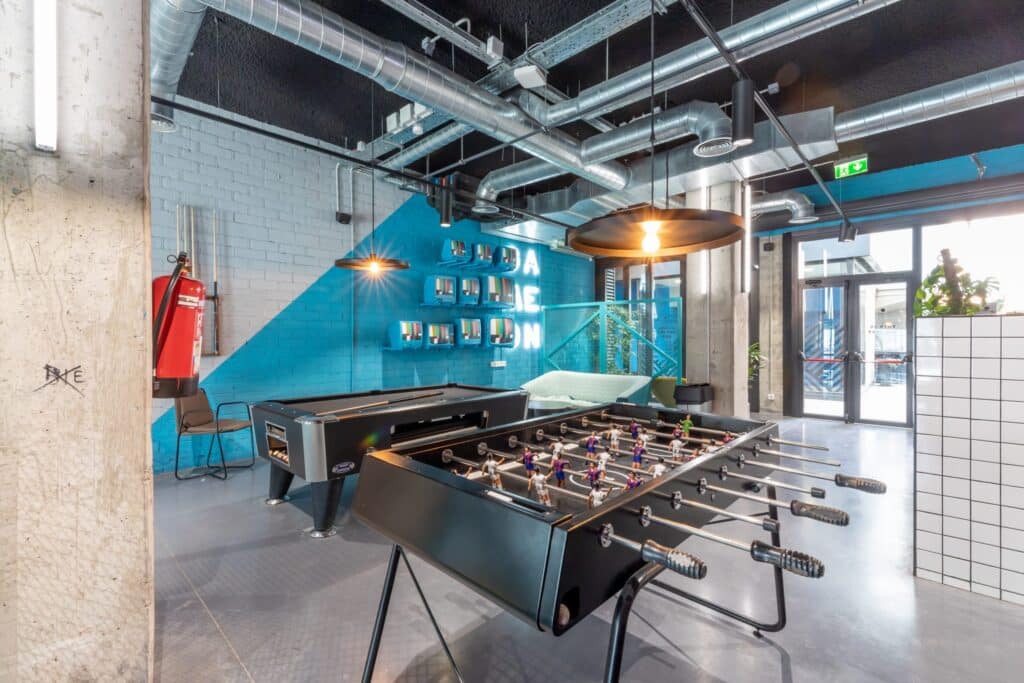 Common area of Beyoo Living with a pool table, soccer table and blue walls