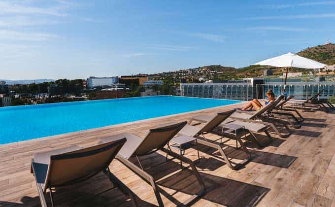 A rooftop pool with loungers and a fantastic view of Barcelona at student residence Livensa Living 